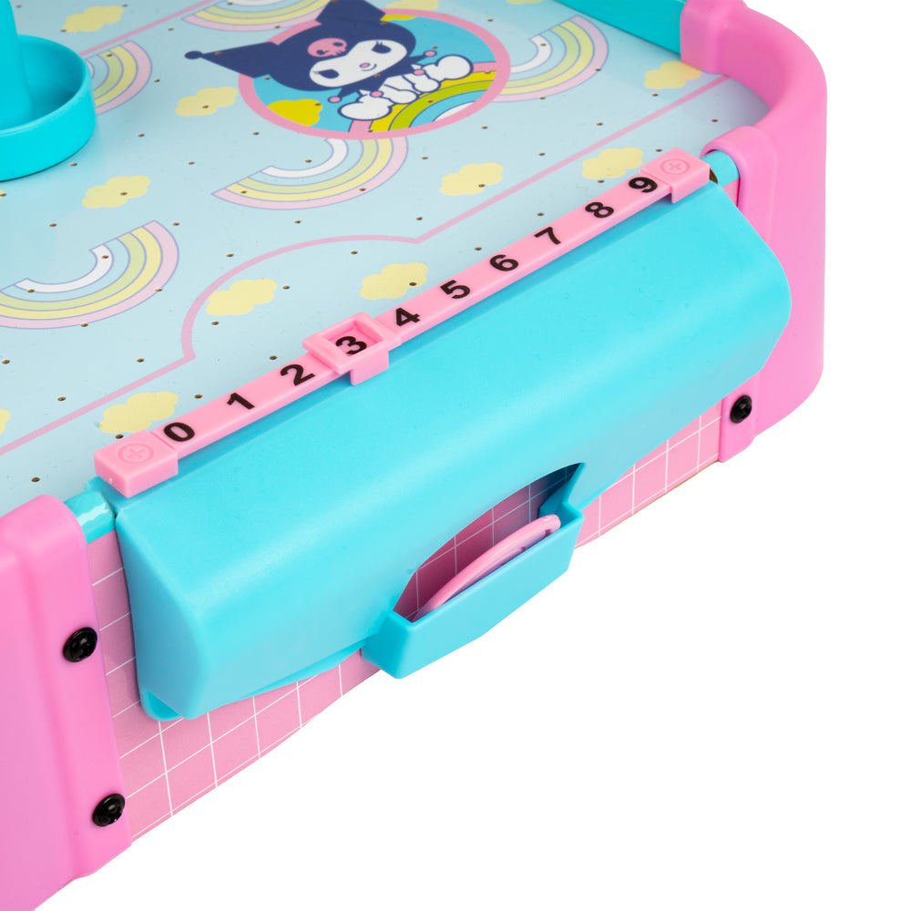 Close-up of a colorful plastic toy or game component with pink and turquoise sections, numbered sliding pieces, and a cartoon character printed on the surface against a white background.