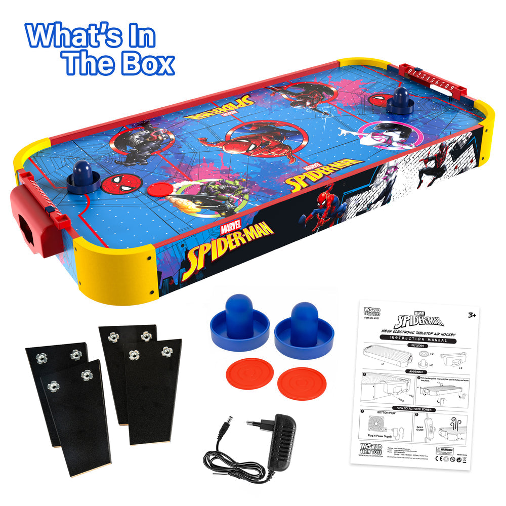 Marvel Spider-Man themed air hockey game set with a blue and red playfield, yellow side bumpers, red and blue discs, black boards, blue paddles, a power cord, and an instruction booklet on a white background with 'What's In The Box' text.
