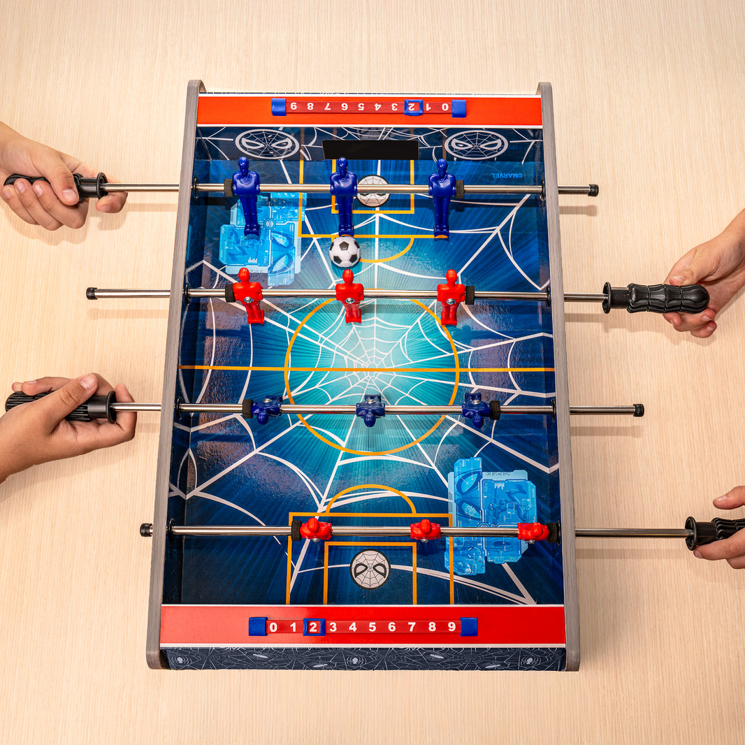 Tabletop foosball game with players using handles on a wooden surface